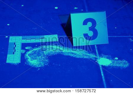 Traces of crime under UV light in bathroom