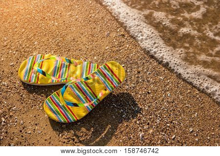 Flip flops on sand background. Footwear on shore. Go to the seaside. Summer at the tropical island.