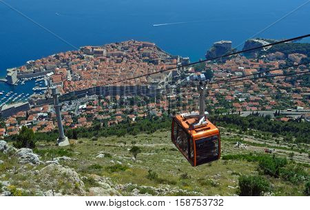 Dubrovnik Cable Car takes tourists from the old town to the top of Mount Srd. Old town city wall and the Adriatic sea in background.