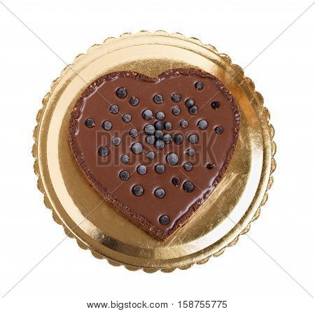 Delicious chocolate cake with blueberries in form of heart on golden cardboard stand. Isolated on a white background.