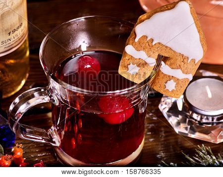 Hot toddy on wooden table surrounded by candles. Hot drink floating berries. Top view.