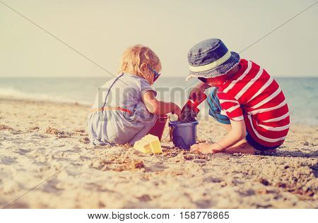 kids play with sand on summer tropical beach