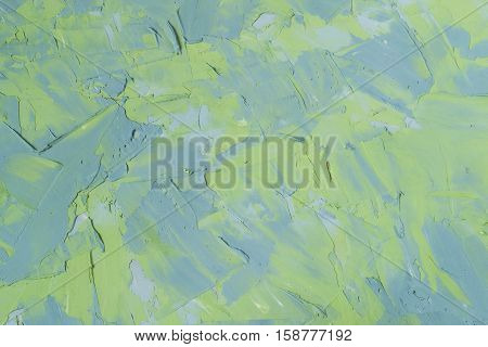 Abstract textured background: mixture of blue and green putty. Uneven strokes rough texture of a wall pattern