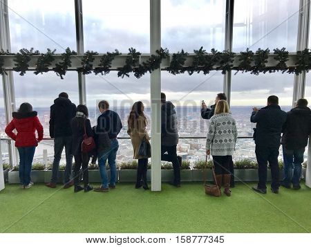 LONDON - NOVEMBER 27: People observing up to 40 miles away across the urban sprawl below from the outdoor gallery on level 72 of The View from The Shard the on November 27, 2016 in London, UK.