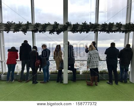 LONDON - NOVEMBER 27: People observing up to 40 miles away across the urban sprawl below from outdoor gallery on level 72 of The View from The Shard the on November 27, 2016 in London, UK.