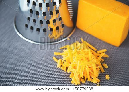 Grated  yellow cheese and grater on a background