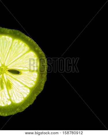 Slice of ripe Half lime isolated  in the dark