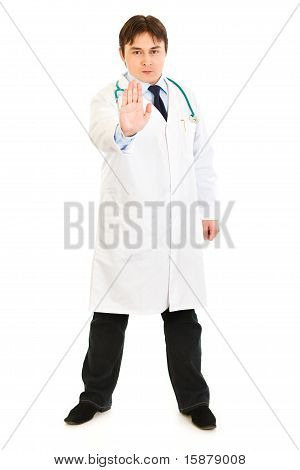 Doctor en medicina autorizado mostrando parada gesto aislado en blanco