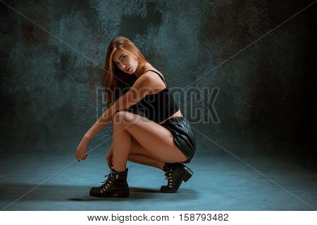 Attractive girl dancing twerk iat the blue studio background