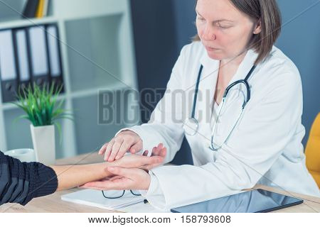 Female patient at orthopedic medical exam in doctor's hospital office traumatology and medical consultation for hand wrist injury