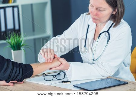 Female patient at orthopedic medical exam in doctor's hospital office traumatology and medical consultation for hand wrist injury