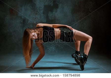 Attractive girl dancing twerk iat the blue studio background