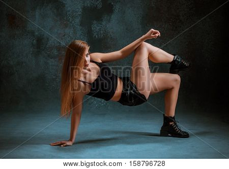Attractive girl dancing twerk iat the blue studio background