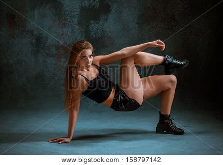 Attractive girl dancing twerk iat the blue studio background