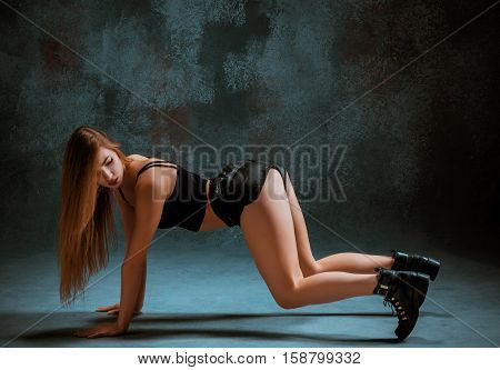 Attractive girl dancing twerk iat the blue studio background