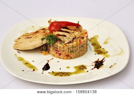 Plate with shaped boiled rice with vegetables and piece of roasted chicken.