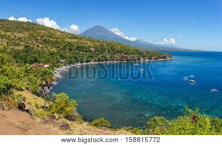 Jemeluk Beach and beautiful blue lagoon with Gunung Agung volcano on background. Amed village, East of Bali, Indonesia.
