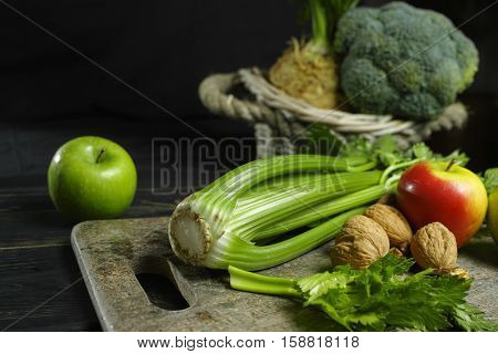 Ingredients for Waldorf salad - celery apples walnuts - fresh and healthy vegetables on granite board.