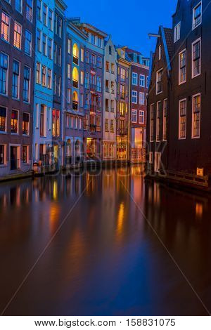Houses over canal with reflections at night close up, Amstardam, Netherlands
