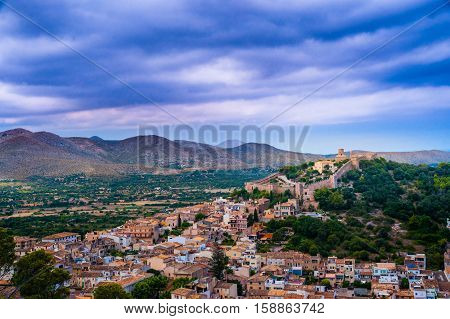 Capdepera castle on green hill in Mallorca island, Spain.