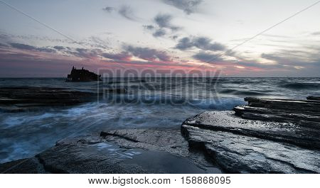 Shipwreck of an abandoned ship on a rocky coast at Akrotiri Beach in Cyprus