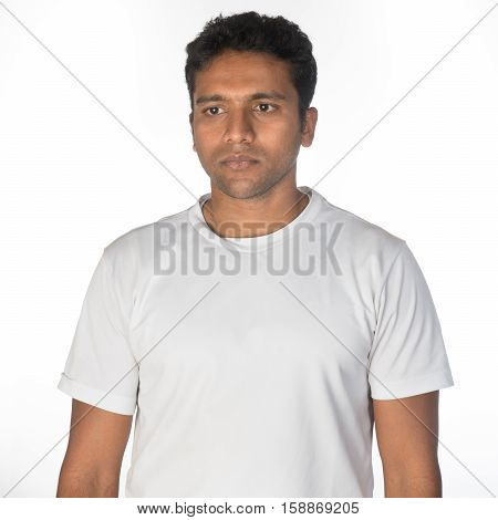 A thoughtful Indian Asian young man looking off camera in studio shot isolated on white