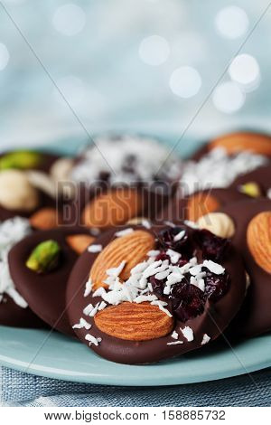 Mendiant traditional French chocolate candy for Christmas holiday. Homemade dessert with nuts and dried fruits. Xmas food.
