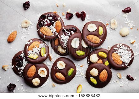 Mendiant traditional French chocolate candy for Christmas holiday from above. Homemade dessert with nuts and dried fruits. Xmas food. Flat lay.