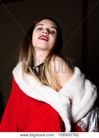 beautiful female nurse sexy woman in carnival costume, on her shoulders a red fur coat.