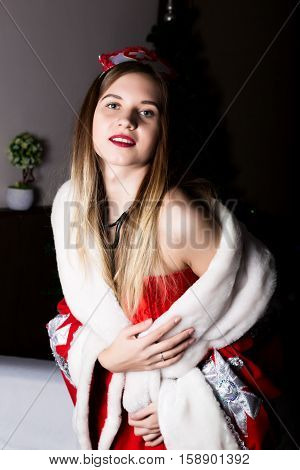 beautiful female nurse sexy woman in carnival costume, on her shoulders a red fur coat.