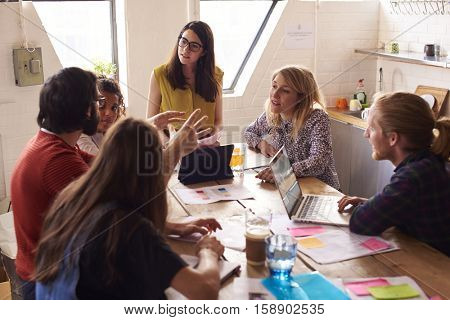 Female Manager Leads Meeting Around Table In Design Office