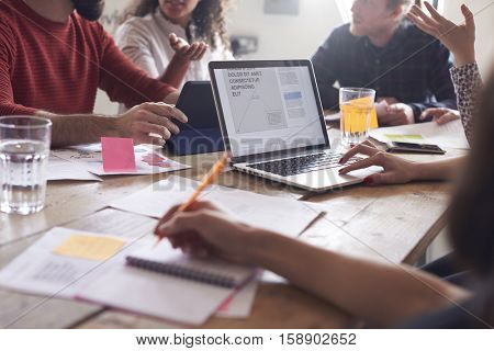 Close Up Of Designers Meeting Around Table In Office