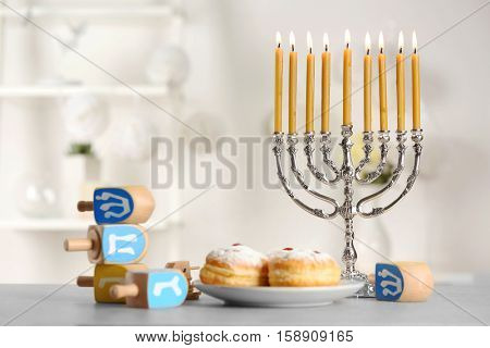 Beautiful composition for Hanukkah on grey table against blurred background