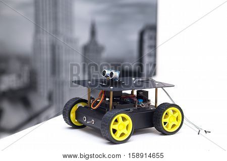 metal robot with yellow wheelsI stands on a white table