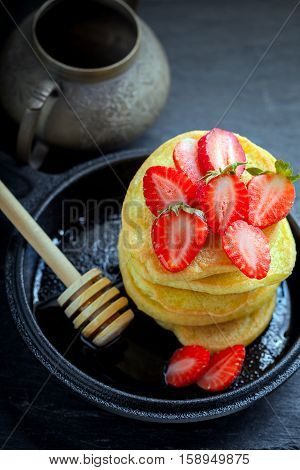 Stack of sweet pancakes with strawberry and honey. Gluten free flour.