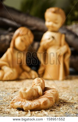 the holy family, the Child Jesus, the Virgin Mary and Saint Joseph in a rustic nativity scene, with the focus on the Child Jesus