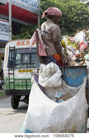 Illustrative image. Pondicherry, Tamil Nadu, India - March 03, 2014. Household waste pastic pick up in the village. Women workers Plastic bottles, papers, bin