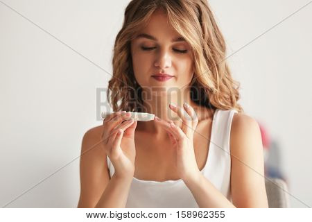 Woman using lancelet on finger