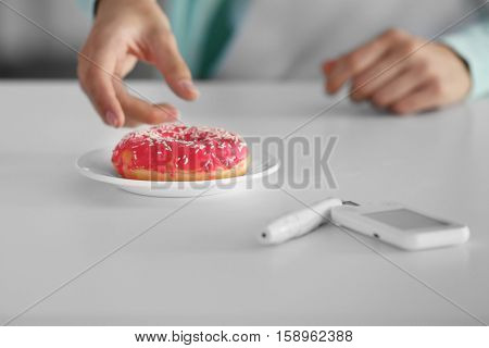 Woman with diabetes going to eat tasty donut