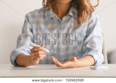 Woman using lancelet on finger