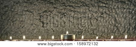 Menorah with the glitter lights of candles and stone background