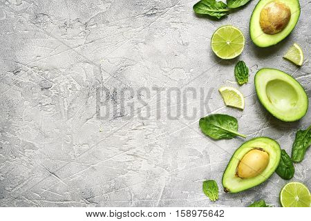 Avocado Halves With Lime Slices And Baby Spinach Leaves.top View.