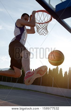 Young Man Jumping And Making A Fantastic Slam Dunk Playing Stree