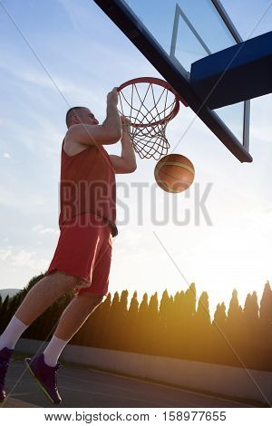 Young Man Jumping And Making A Fantastic Slam Dunk Playing Stree