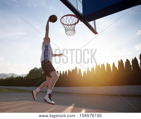 Young Man Jumping And Making A Fantastic Slam Dunk Playing Stree