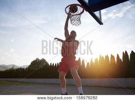 Young Man Jumping And Making A Fantastic Slam Dunk Playing Stree