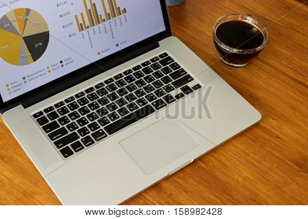 Laptop and coffee cup on old wooden table