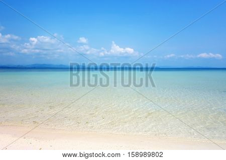 White clouds on blue sky over calm sea. Clear blue sky with fantastic white sand beach with calm ocean Summer outdoor nature holiday serenity. Talu Island Prachuap Khiri Khan Thailand.
