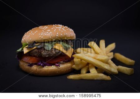 Burger and French fries. black background. fastfood.