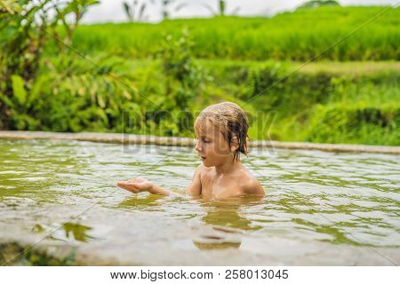 Boy Tourist In Belulang Hot Springs In Bali On The Background Of Rice Terraces Traveling With Childr